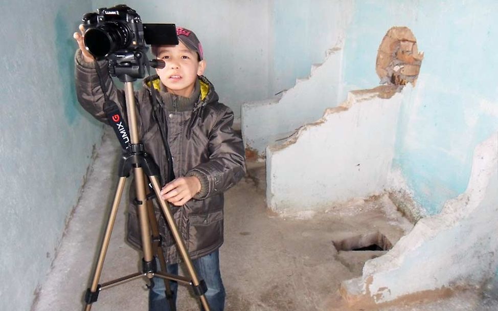 Kanymet (14) bei Filmarbeiten in der Schultoilette in Chelpek. © UNICEF/Chris Schüpp/2014