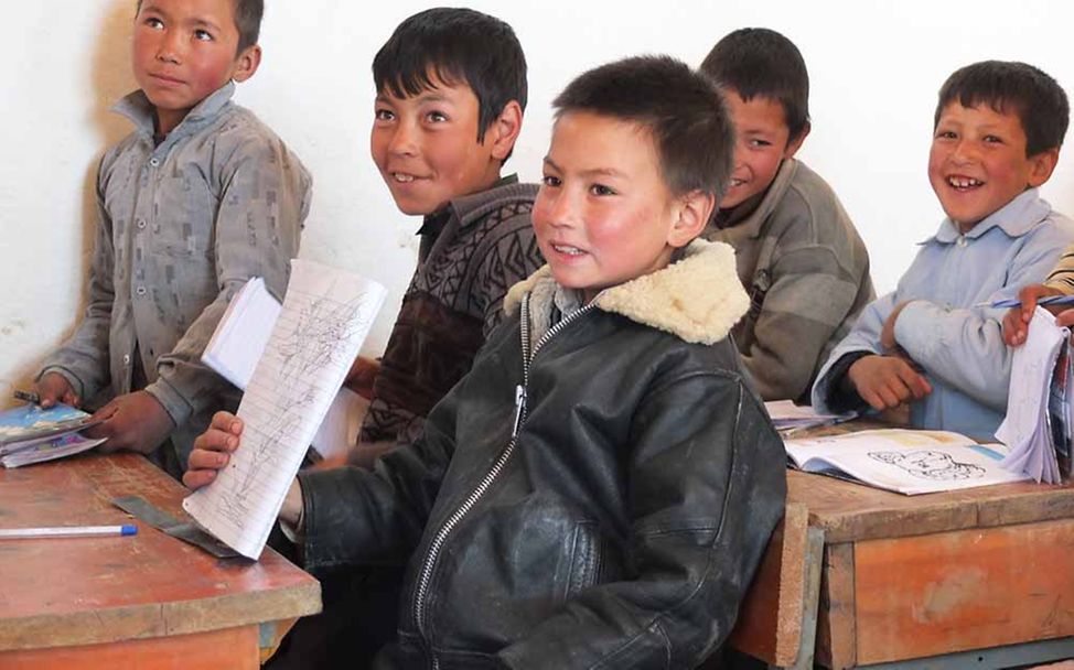 Afghanistan: Jungen in einer Schulklasse zeigen stolz, was sie geschrieben haben.