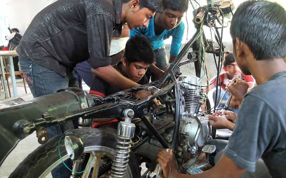 Ausbildungen für Jugendliche in Bangladesch: Jugendliche schrauben an einem Motorrad. 