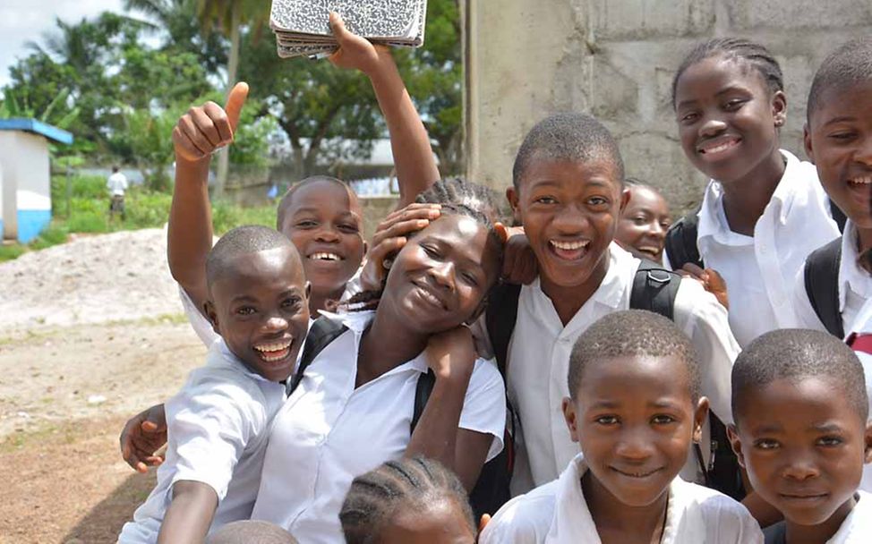 Liberia: Eine fröhliche Gruppe von Schulkindern in weißen Schulhemden. 