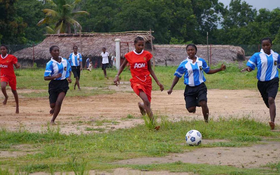 Madagaskar Let Us Learn: Mädchen spielen in der Schule zusammen Fußball.