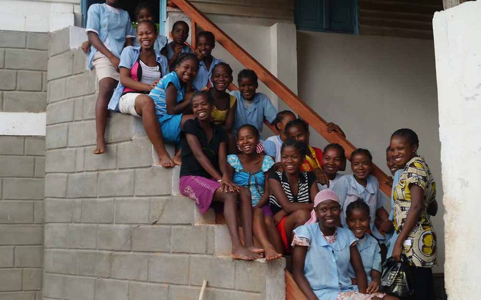 Madagaskar Let Us Learn: Schülerinnen einer Mädchenklasse sitzen auf der Treppe vor ihrem Klassenzimmer.