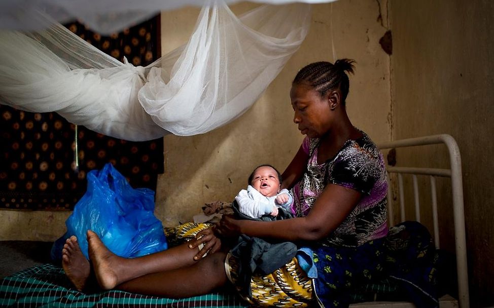 Sierra Leone: Mutter mit Baby in Gesundheitsstation unter Moskitonetz