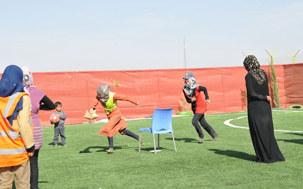 Azraq Camp: Rouba spielt mit ihren Freundinnen im UNICEF-Jugendzentrum im Azraq Camp ein Fangspiel.